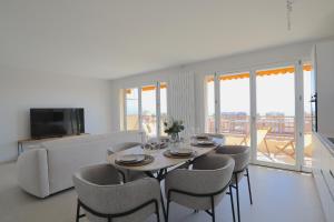 a living room with a table and chairs and a couch at Luxury 2bedrms with SeaView CityCenter&Parking #4 in Roquebrune-Cap-Martin