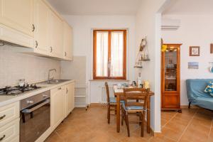 a kitchen with white cabinets and a table with chairs at Casa Baldi Lajatico in Laiatico