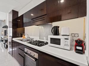 una cucina con forno a microonde e fornello forno superiore di Sunlit Studio Haven - Luxury Living in Majestine a Dubai