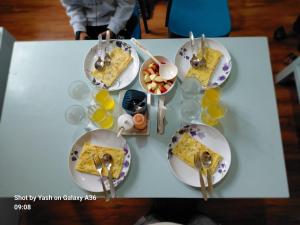 a table with plates of food and bowls of fruit at Valley Mist rooms & kitchen in Ravangla