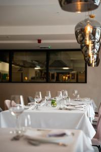a table with wine glasses on it in a restaurant at Hotel Rubin DHS in Kruševac
