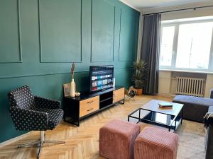 a living room with a tv and a couch and a table at Reval Residences City Center in Tallinn