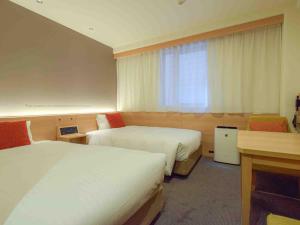 Postel nebo postele na pokoji v ubytování Nishitetsu Inn Shinjuku