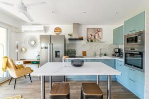 una cucina con tavolo bianco e armadi blu di Panoramic vue cassis a Cassis