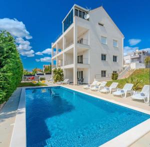 a villa with a swimming pool in front of a building at Villa Carlotta in Zadar