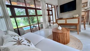 a living room with a white couch and a tv at Villa La Golden Monkey, Villa 24 in Chaweng Noi Beach