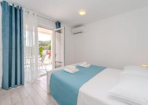 a bedroom with a bed with blue sheets and a balcony at Villa Carlotta in Zadar +71 photos
