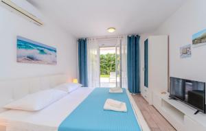 a white bedroom with a large bed and a television at Villa Carlotta in Zadar