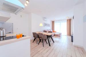 a kitchen and living room with a table and chairs at Villa Carlotta in Zadar