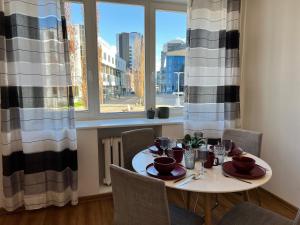 a dining room table with chairs and a table and a window at Reval Residences City Center in Tallinn