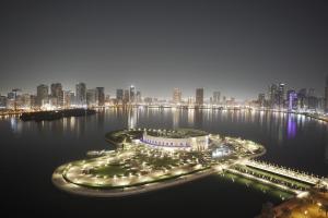 a view of a city at night with lights at Copthorne Hotel Sharjah in Sharjah