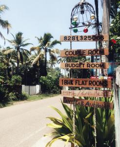 a bunch of signs on a pole next to a road at Standard Staycation in Varkala +2 photos