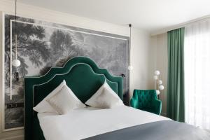 a bedroom with a bed with a green headboard at Schloßhotel Althörnitz in Hörnitz