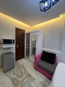 a living room with a pink couch and a microwave at Studio beverly hills premium sheikh Zayed in Sheikh Zayed