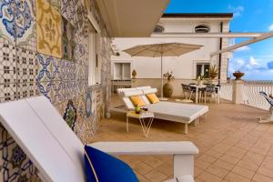 a patio with a white couch and an umbrella at Celebrity Suite - Big Terrace on the Sea in Praiano +25 photos