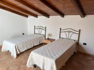 two beds sitting next to each other in a room at Dimora storica Gallurese vicino al Lago in Sant Antonio Di Gallura