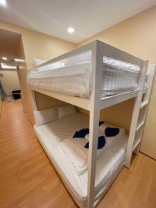 a bunk bed with white bunk beds in a room at High Lamoon in Sathani Khlong Rian
