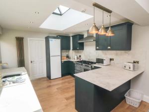 ブリドリントンにあるWellington Houseのキッチン(緑のキャビネット、カウンタートップ付)