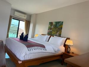 a bedroom with a large white bed with a window at Laph Kham House in Chiang Mai +130 photos