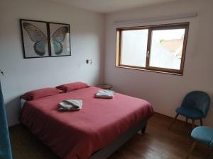 ein Schlafzimmer mit einem Bett mit einer roten Decke und einem Fenster in der Unterkunft Maison ecologique avec jardin in Elne