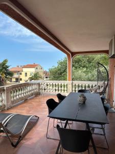 un patio avec une table et des chaises sur un balcon dans l'établissement Apartment Peloža 1, à Poreč