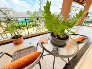 a glass table with plants on a balcony at Laph Kham House in Chiang Mai