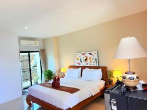 a bedroom with a bed and a desk with a lamp at Laph Kham House in Chiang Mai