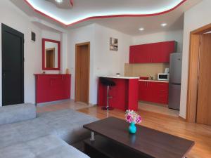 代诺维奇Apartman Stella Đenovići的一间带红色橱柜的客厅和一间厨房