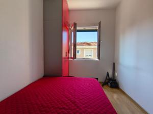 代诺维奇Apartman Stella Đenovići的窗户客房内的一张红色的床
