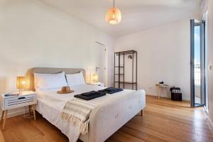 a white bedroom with a large white bed with two lamps at Casas do Forte by MY CHOICE in Tavira +173 photos