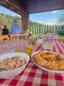 a table with plates of food on a red and white checked table cloth at Apartamenty Agroturystyczne Papiernia in Niedźwiedź