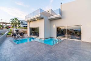a house with a swimming pool in front of it at Jarko Luxury Houses in Argoulidhés