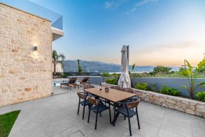 an outdoor patio with a wooden table and chairs at Jarko Luxury Houses in Argoulidhés