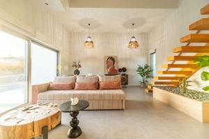 a living room with a couch and a staircase at Jarko Luxury Houses in Argoulidhés