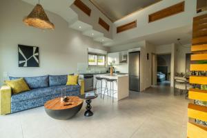 a living room with a blue couch and a kitchen at Jarko Luxury Houses in Argoulidhés