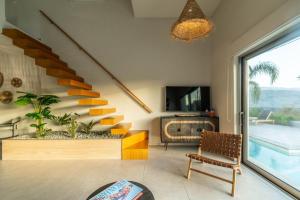 a living room with a staircase and a chair at Jarko Luxury Houses in Argoulidhés