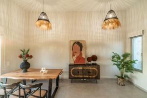 a dining room with a table and two potted plants at Jarko Luxury Houses in Argoulidhés