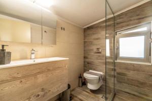 a bathroom with a toilet and a sink and a shower at Jarko Luxury Houses in Argoulidhés