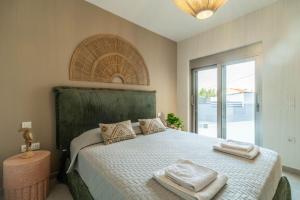a bedroom with a large bed with towels on it at Jarko Luxury Houses in Argoulidhés