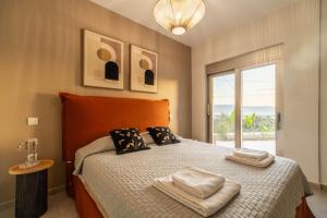 a bedroom with a bed with two towels on it at Jarko Luxury Houses in Argoulidhés