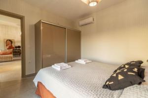 a bedroom with a bed with towels on it at Jarko Luxury Houses in Argoulidhés