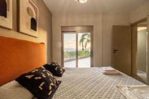 a bedroom with a bed with a view of the ocean at Jarko Luxury Houses in Argoulidhés