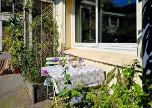 a table in front of a window with flowers on it at Loft Évasion aux Portes de Paris in Bagnolet