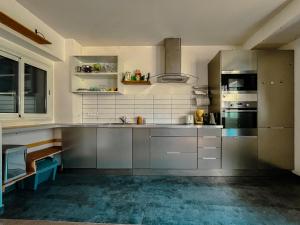 a kitchen with stainless steel cabinets and appliances at Loft Évasion aux Portes de Paris in Bagnolet