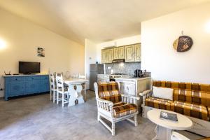 a living room with a couch and a table and a kitchen at Villa Alba in Costa Paradiso