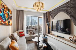 a living room with a couch and a tv at Dune Escape Stylish Poolside Courtyard Retreat in Dubai