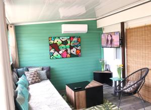 a living room with a couch and a green wall at Le Mobil home de Domi in Puget-sur Argens