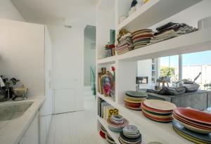 a kitchen with white walls and shelves filled with plates at Italian Experience-Villa Rosa Del Mare in Marzocca di Senigallia +55 photos