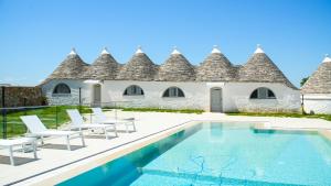 a villa with a swimming pool in front of a building at Masseria Surace in Noci