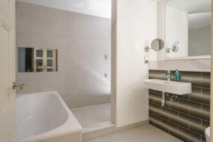 a bathroom with a tub and a sink and a shower at Fanhams Hall, Exclusive Collection in Ware